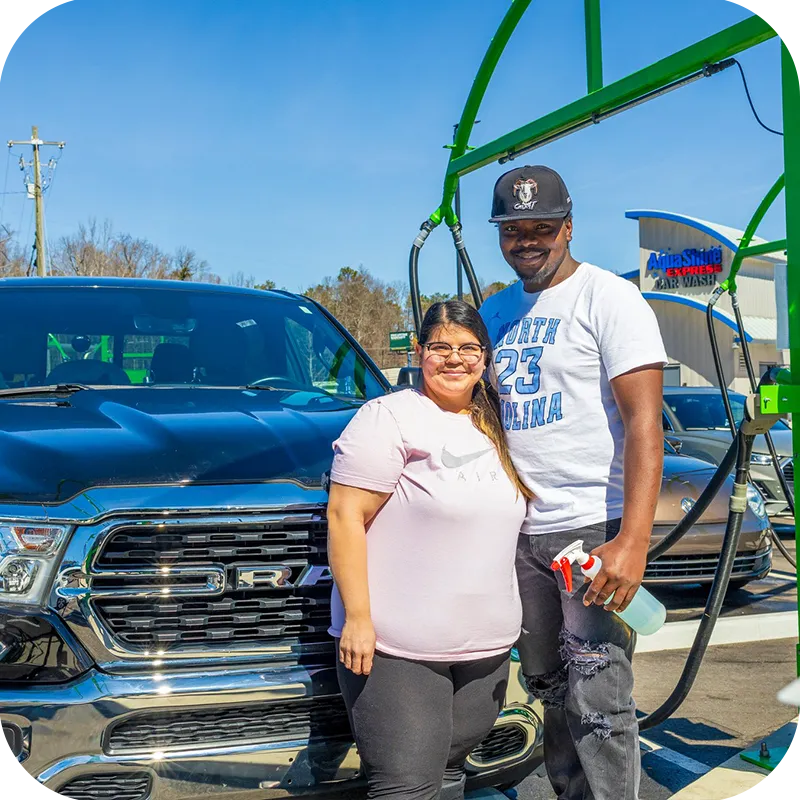 AquaShine Express Car Wash happy couple in front of truck using the wash supplies after going through the express tunnel