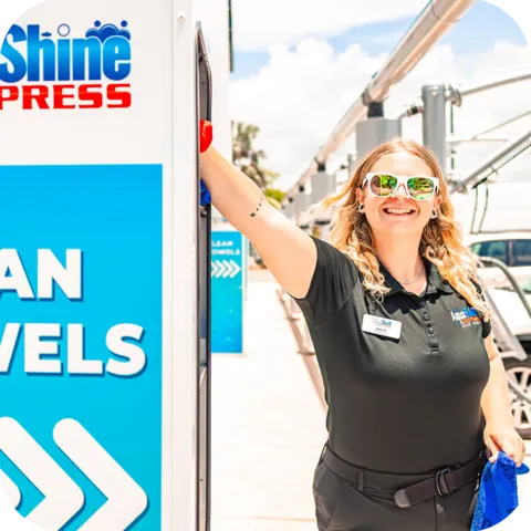 Happy AquaShine Express Car Wash team member working outdoors at an express car wash